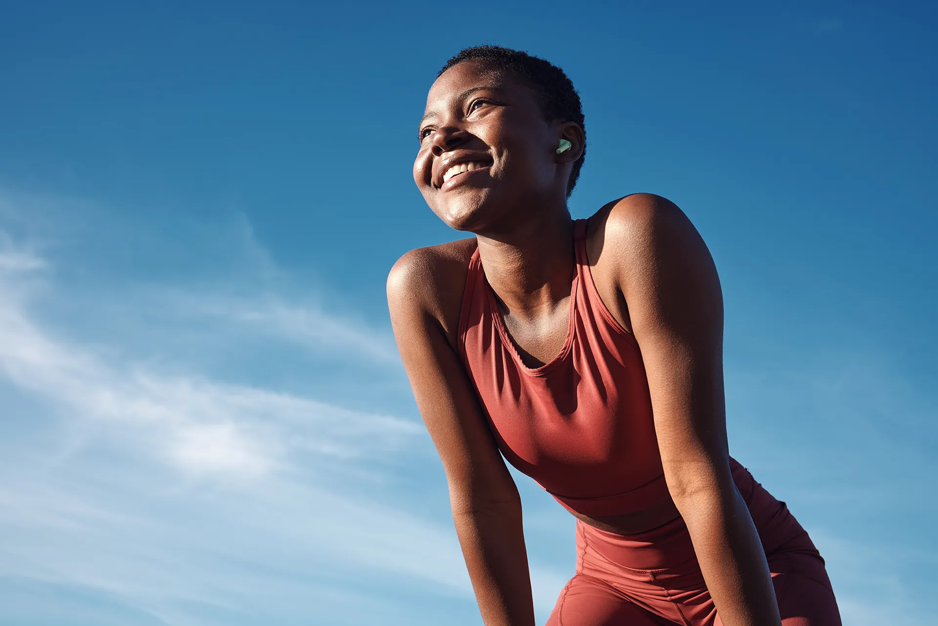 exercise-banner woman resting after running with blue sky background